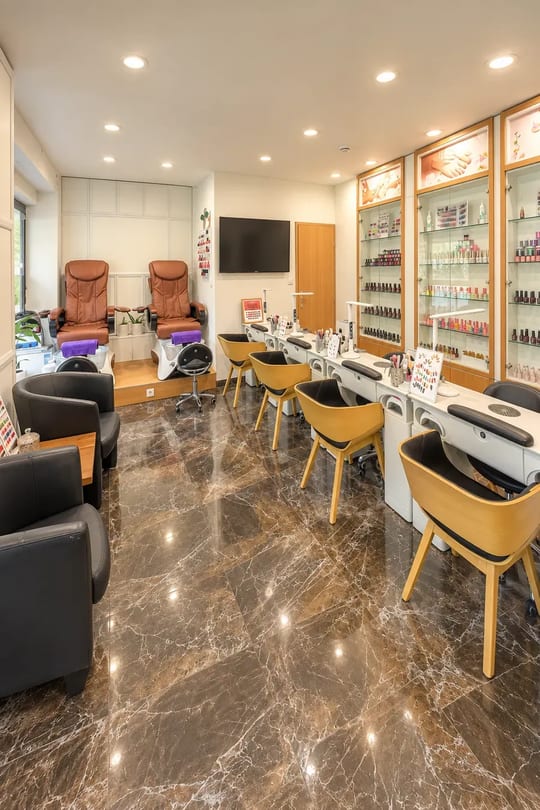 Interiér štúdia Queen Bee Nails – pracovné stoly na manikúru, pedikúrne kreslá a vitríny s lakmi