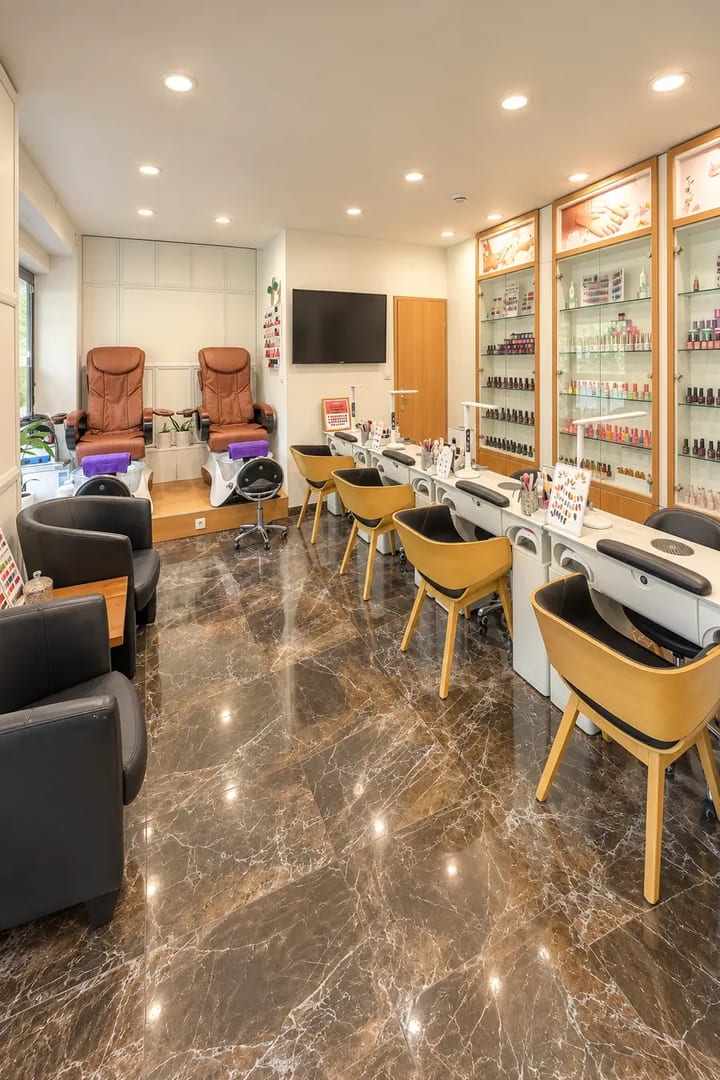 Interiér štúdia Queen Bee Nails – pracovné stoly na manikúru, pedikúrne kreslá a vitríny s lakmi